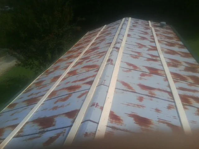 Rusted metal roof panels with new wood purlins before replacement — Storm Damage Roof Repair in Covington by Roofing Brothers